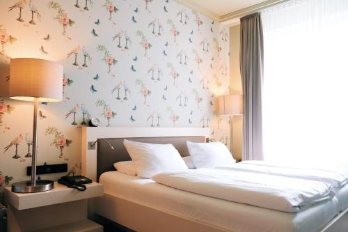 a bedroom with a bed with a floral wallpaper at Zum Löwen Design Hotel Resort & Spa in Duderstadt