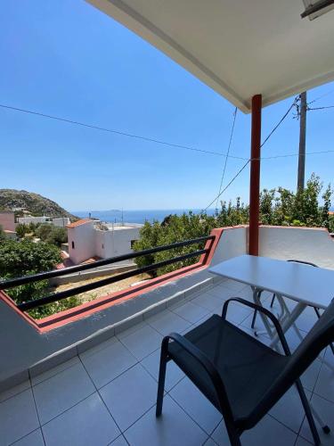 a white table and a chair on a balcony at Archontika Apartments in Kerames