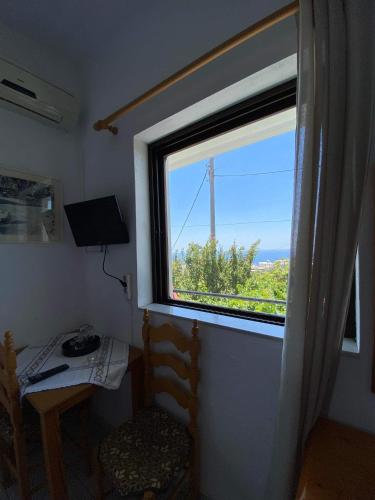 a window in a room with a table and a chair at Archontika Apartments in Kerames