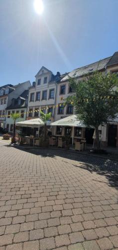 a large building with tables and umbrellas in a courtyard at Stadthotel in Rochlitz