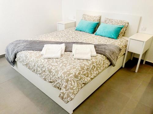 a bed with blue and white pillows on it at Casita Vito Fuerteventura in Costa Calma