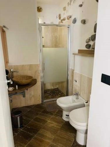a bathroom with a toilet and a sink at Il Daviduccio Suite in Siracusa
