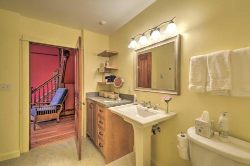 Un baño con lavabo, inodoro y espejo. en Historic, Victorian Villa with Park On-Site, en Quilcene