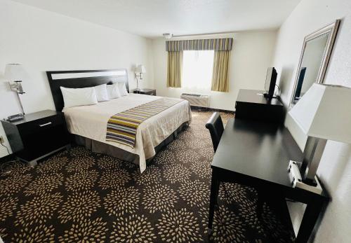 a hotel room with a bed and a desk at Court Plaza Inn & Suites of Mackinaw in Mackinaw City