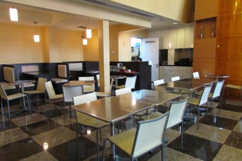 a restaurant with tables and chairs and a kitchen at Strand Hotel in Singapore