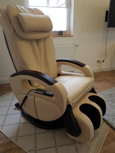 a reclining chair with a remote control sitting on a rug at Sommerhaus (am Landhaus von Felde) in Esens