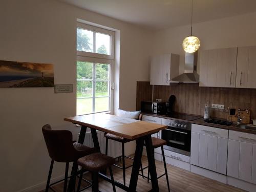 a kitchen with a table and chairs and a window at Sommerhaus (am Landhaus von Felde) in Esens
