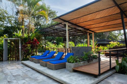 a patio area with chairs, tables and umbrellas at Noah's Forest Hotel by Tifakara in Fortuna