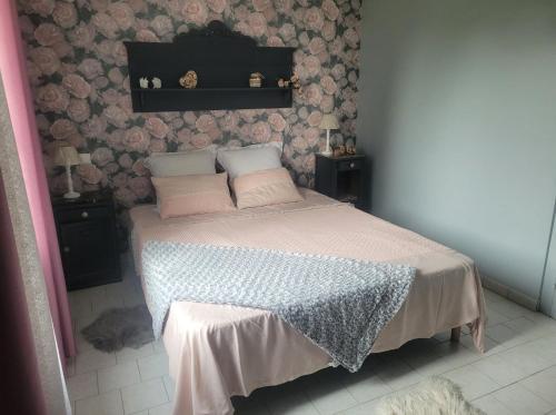 - une chambre dotée d'un lit avec des draps roses et blancs dans l'établissement l'Eden du sancerrois, à Sens-Beaujeu