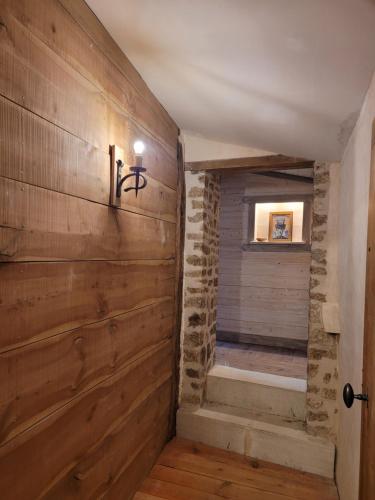 einen Flur mit Holzwand und Treppe in einem Haus in der Unterkunft La Cressonnière in Parthenay