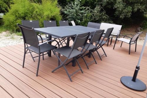 a black table and chairs on a wooden deck at Maison Tamaris avec jardin et clos in Quiberon