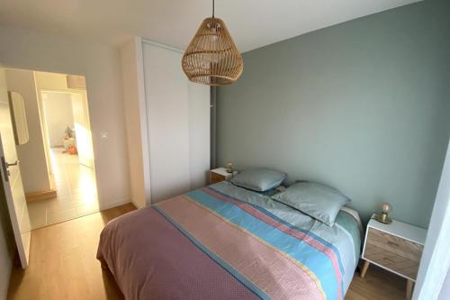 1 dormitorio con 1 cama y luz colgante en Residence 350 meters from the main beach chez lena, en Quiberon