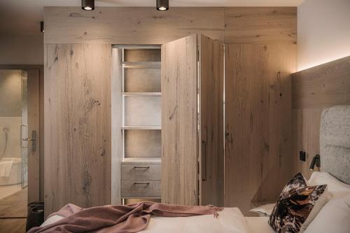 a bedroom with a wooden cabinet and a bed at Hotel Post in Kaltenbach