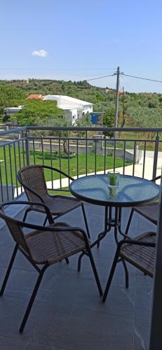 a table and chairs on a balcony with a view of the ocean at Vot villas in Ormos Panagias