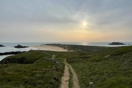 a dirt road leading to a beach at sunset at Appartement Rue de la gare centre ville in Quiberon