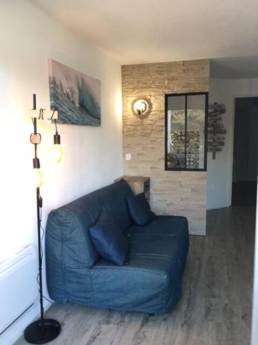 - un canapé bleu dans le salon dans l'établissement Appart Port haliguen résidence piscine et plage, à Quiberon