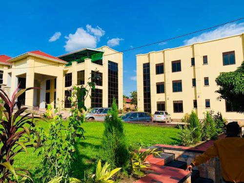 a man sitting on a bench in front of a building at Golden Castle Hotel Hoima in Hoima