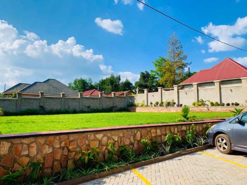 a car parked in a parking lot next to a wall at Golden Castle Hotel Hoima in Hoima