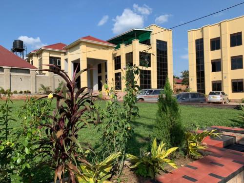 a large building with a lawn in front of it at Golden Castle Hotel Hoima in Hoima