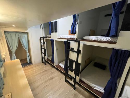 a dorm room with three bunk beds in it at 黑背包 Black Backpack 艙房式背包床 in Xiaoliuqiu