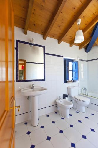 a bathroom with two toilets and a sink and a mirror at Casa Rural Camangu in Camango