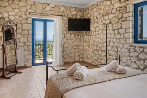 a bedroom with a bed and a stone wall at Stone House in olive Grove - former Denis Stone Villa in Trapezaki