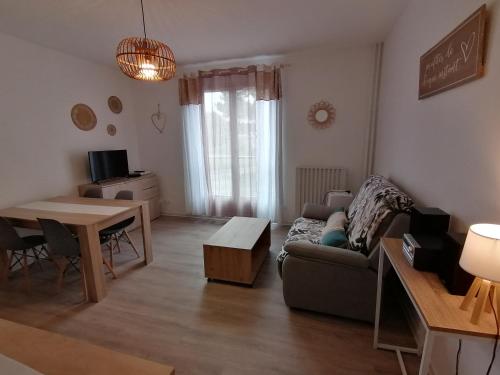 een woonkamer met een bank en een tafel bij L'ESCALE DETENTE EN VERCORS in Saint-Jean-en-Royans
