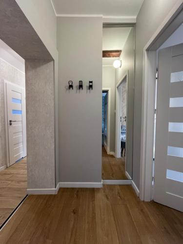 an empty hallway with white walls and wood floors at Apartamenty Dobranocka in Krotoszyn