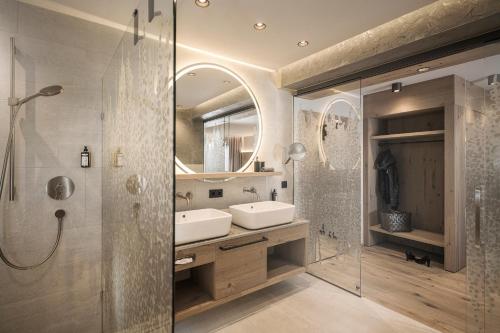 a bathroom with a sink and a shower and a mirror at Hotel Post in Kaltenbach