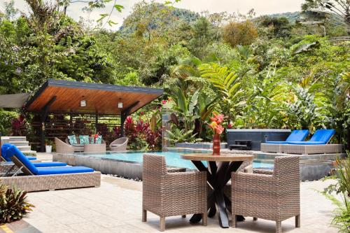 a table with chairs and a patio area at Tifakara Boutique Hotel & Birding Oasis in Fortuna
