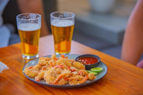 a plate of food on a table with two glasses of beer at Villa Vanna in Unawatuna