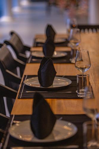 a row of tables with wine glasses and hats on them at Villa Vanna in Unawatuna