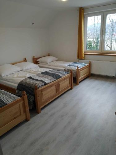 a bedroom with three beds and a window at Willawil in Karpacz