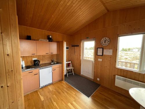 a kitchen with wooden walls and wooden floors and a window at Gotta Cottages in Selfoss