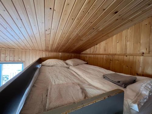a bed in a room with a wooden ceiling at Gotta Cottages in Selfoss