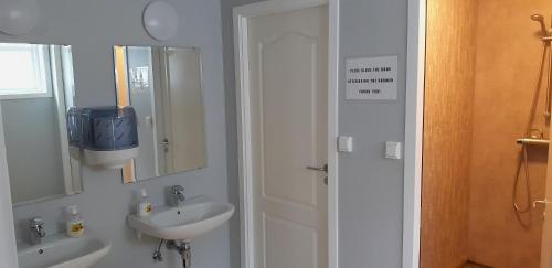 a white bathroom with a sink and a mirror at Wathne Camping in Bjørheimsbygda