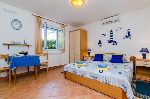 a bedroom with a bed and a table and a window at Small and friendly traditional home in Zaton