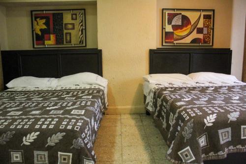 two beds in a hotel room with two bedsskirts at Hotel Regis in Monterrey