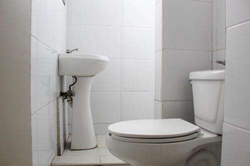 a white bathroom with a toilet and a sink at Hotel Regis in Monterrey