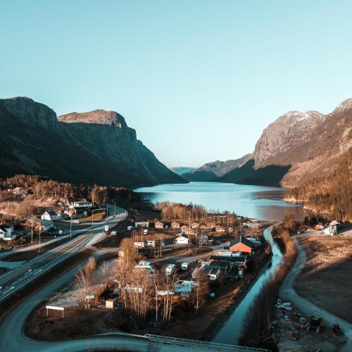arial view of a town next to a river and mountains at Wathne Camping in Bjørheimsbygda