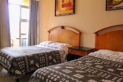 a hotel room with two beds and a window at Hotel Regis in Monterrey