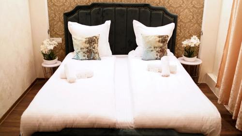 a bedroom with two beds with white sheets and pillows at pensiunea medellin in Tulcea