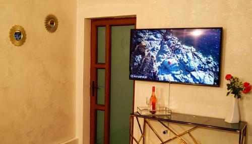 a living room with a television on a wall at pensiunea medellin in Tulcea