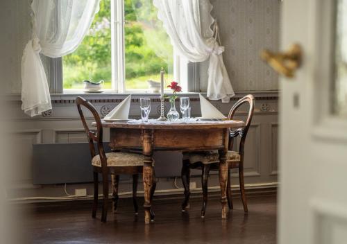Husum Hotel في Borgund: طاولة طعام مع كؤوس نبيذ وشمعة
