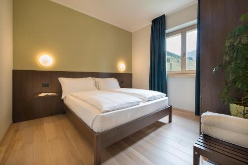 ein Schlafzimmer mit einem Bett und einem großen Fenster in der Unterkunft Central Rin in Livigno