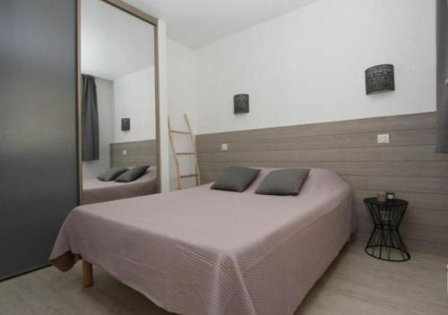 - une chambre avec un grand lit et un miroir dans l'établissement 6 - Résidence St Raphaël Valescure, à Saint-Raphaël