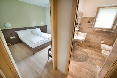 Baño pequeño con cama y lavabo en Central Rin, en Livigno