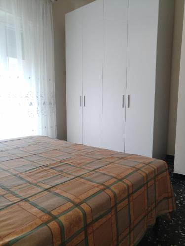 een slaapkamer met een bed en witte kasten bij Interno2 in Diano Marina