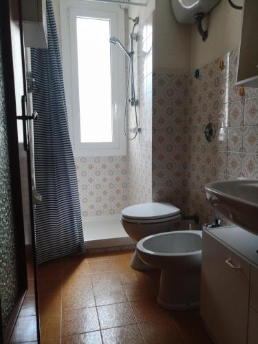 een badkamer met toilet, wastafel en raam bij Interno2 in Diano Marina