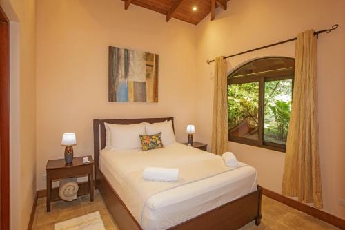 1 dormitorio con cama y ventana en Three Bedroom Two Bath Villa on 20 Acres of Nature! "Hana's Celeste Retreat", en Bijagua
